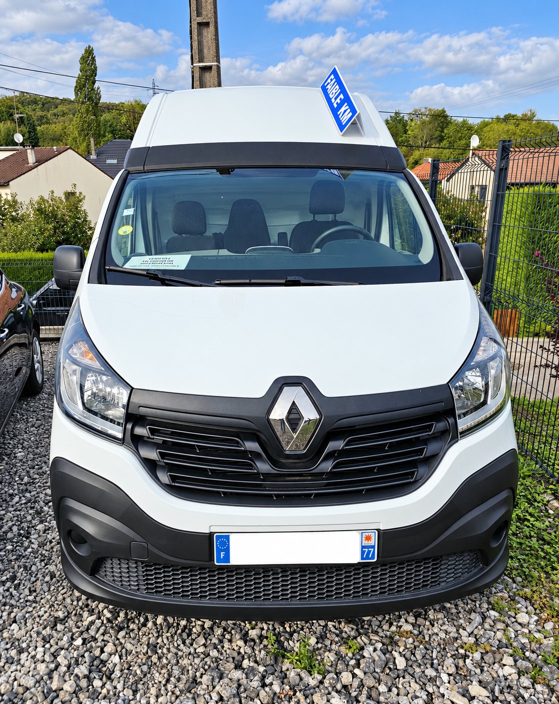 Renault Trafic blanc d’occasion vu de face sur le gravier.